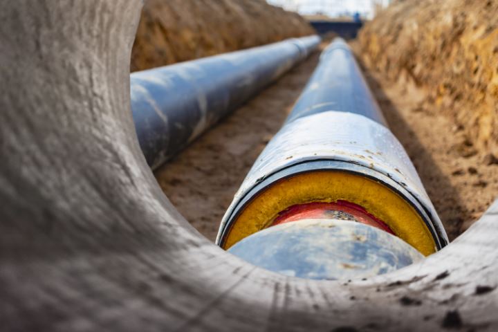 Insulated pipe Large metal pipes with a plastic sheath laid in a trench Modern pipeline for supplying hot water and heating to a residential area